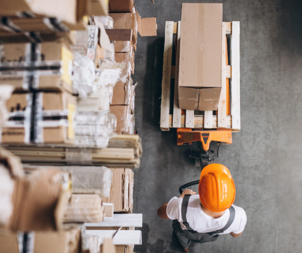 This is an image of a worker moving boxes in a warehouse.